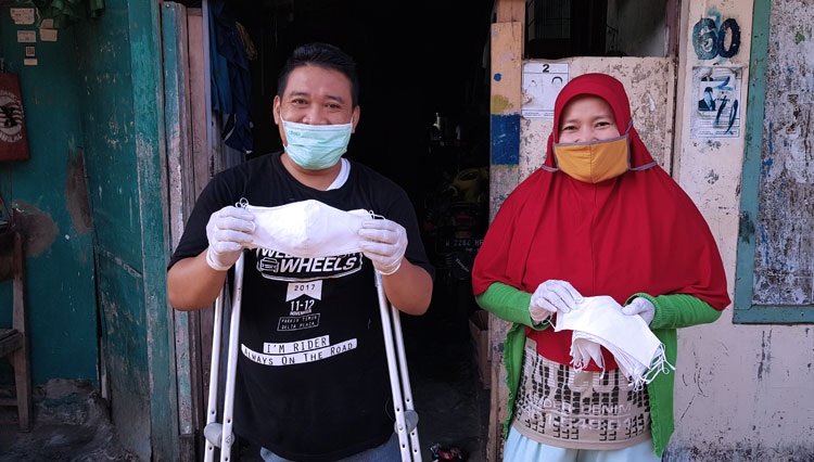 A member of Disable Motorcycle Indonesia community shows his homemade mask. (Photo: Hotel Shangri-La) 