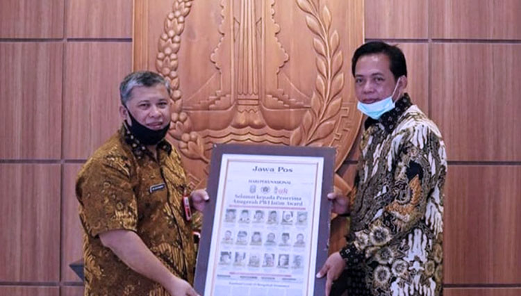 Kepala Bappeda Jatim Rudy Ermawan Yulianto saat menerima Piagam Penghargaan PWI Award Tokoh Birokrasi dari Ketua PWI Jatim Ainur Rohim di Gedung Bappeda Jatim pada 9 Mei 2020.(Foto: Instagram Bappeda Jatim) 