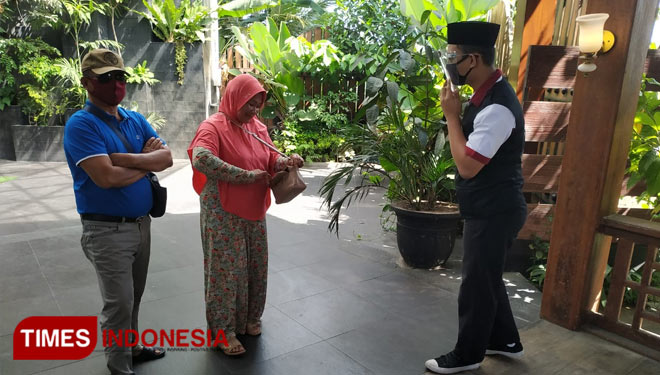 Satgas Covid 19 kampung coklat sedang mengarahkan pengunjung agar mematuhi protokol kesehatan sebelum masuk ke Kampung Coklat, Sabtu (18/7/2020). (Foto: Sholeh/ TIMES Indonesia) 