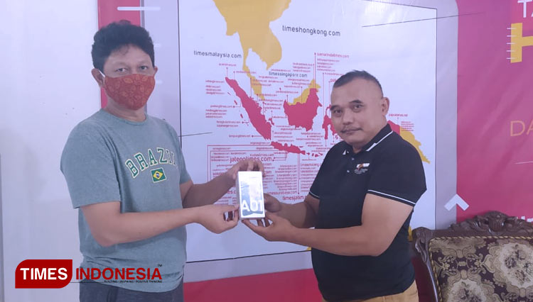 Hari, perwakilan dari Bhawikarsu 89 Malang, menyerahkan sumbangan HP Android yang diterima TIMES Peduli. (Foto: Juli/TIMES Indonesia)