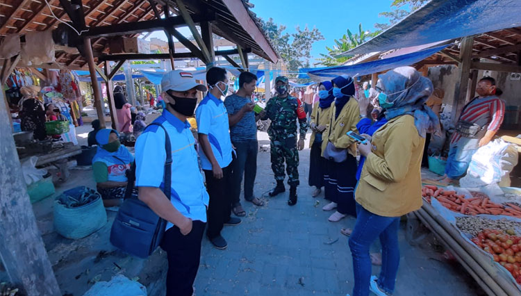 Babinsa Koramil Cimanggu beserta relawan, memberi edukasi terkait protokol kesehatan kepada pengunjung pasar. (Foto: pendim Cilacap for TIMES Indonesia)