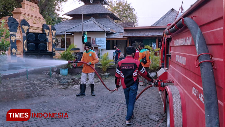 Relawan MBLC melakukan pentemprotan disinfektan di Masjid Kuno Taman dan Lapangan Rejomulyo, Kota Madiun. (Foto: Aditya C/TIMES Indonesia)