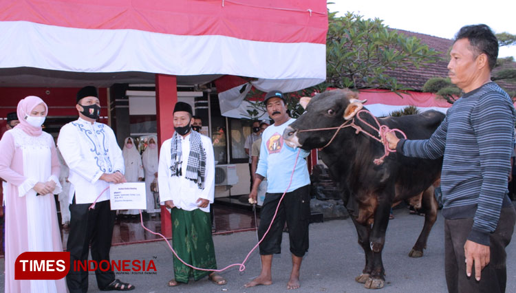 Kapolres Bangkalan AKBP Rama Samtama Putra menyerahkan secara simbolis seekor sapi kepada panitia penyembelihan hewan kurban di Polres Bangkalan. (Foto: Humas Polres Bangkalan/TIMES Indonesia)