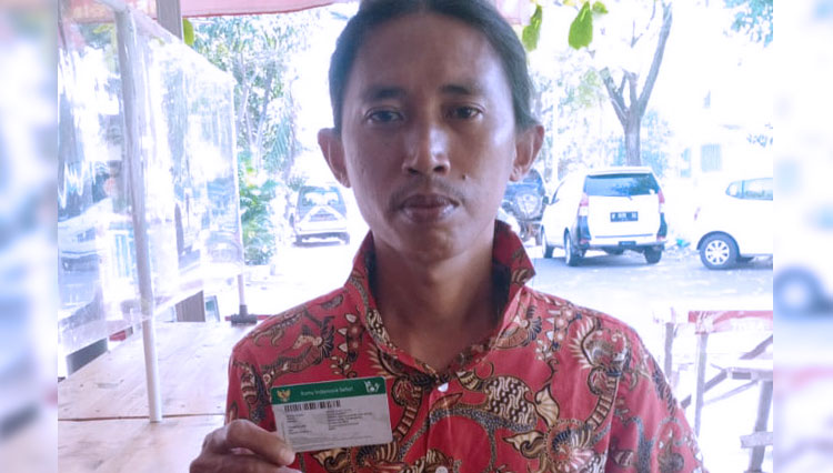 Edi Siswanto saat menunjukkan kartu JKN-KIS. (FOTO: BPJS Kesehatan Gresik for TIMES Indonesia)