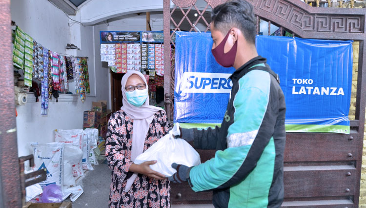 Petugas ojek online mengirimkan pesanan belanja bebas ongkir dari Lumbung Pangan Jatim. (FOTO: Dok.Pemprov Jatim) 