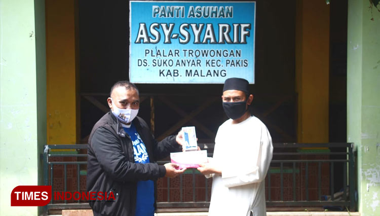 Perwakilan TIMES Indonesia Peduli memberikan bantuan kepada pengasuh Pantia Asuhan Asy-Syarif. (FOTO: Adhitya Hendra/TIMES Indonesia)