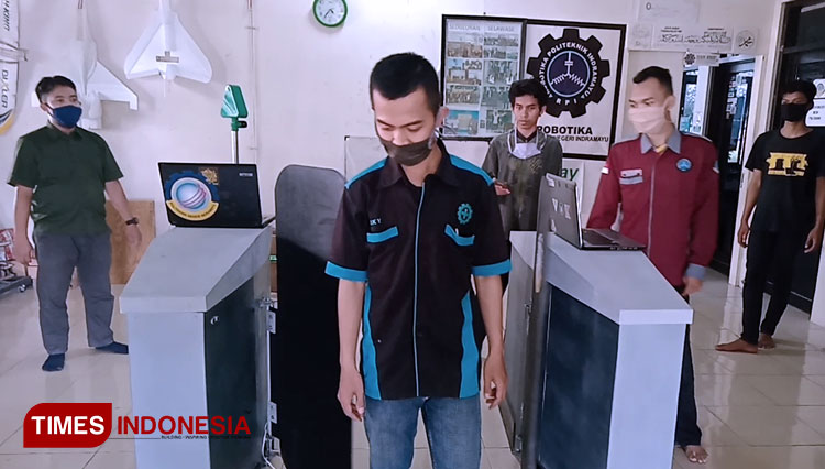 Mahasiswa Politeknik Negeri Indramayu (Polindra) menunjukkan cara kerja pintu pendeteksi masker dan pengukur suhu tubuh secara otomatis karya mereka di kampus Polindra. (Foto: Nurhidayat/TIMES Indonesia)