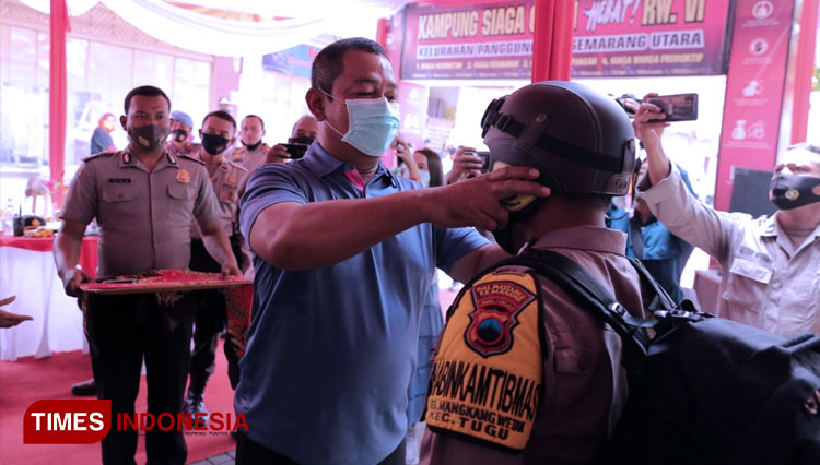 Wali Kota Semarang, Hendrar Prihadi sedang memakaikan masker secara simbolis kepada polisi dalam peresmian kampung siaga. (FOTO: Humas Pemkot Semarang/TIMES Indonesia)