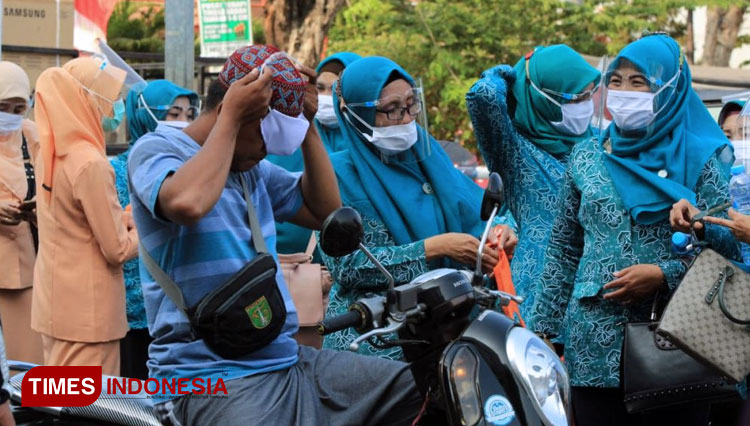 Tim Penggerak PKK Kota Pasuruan bersama Ibu Bhayangkari dan Ibu Persit membagikan masker gratis di sekitar alun-alun dan Pasar Kebonagung, Jumat (7/8/2020). (FOTO: AJP TIMES Indonesia)