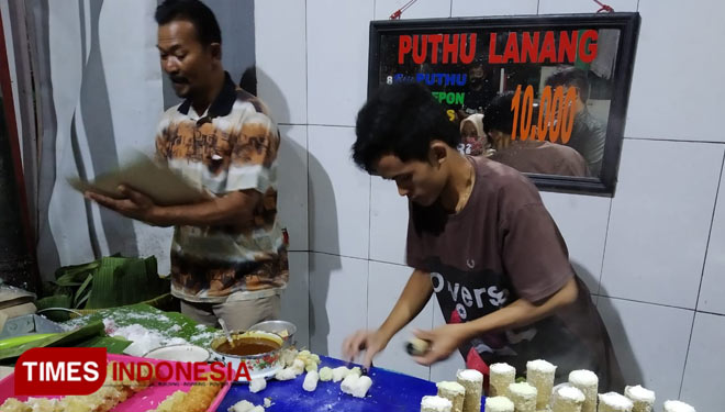 Siswojo, pemilik warung Puthu Lanang dan karyawannya saat melayani pembelinya, Jumat (24/7/2020) (Foto:Mery Cahyani/Times Indonesia)