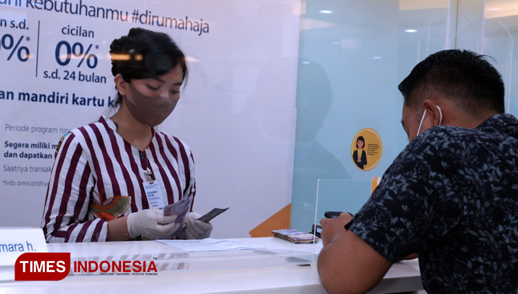 Petugas Bank Mandiri Malang melayani nasabah sesuai protokol kesehatan Covid-19. (Foto: Naufal Ardiansyah/TIMES Indonesia)