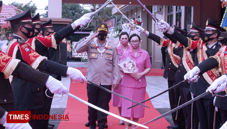 AKBP Boyke Karel Wattimena, SIK. MH saat melewati lingkaran pedang pora bersama istri. (FOTO: Humas polres For TIMES indonesia) 