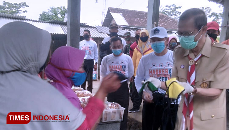 Bupati Magetan, Suprawoto saat membagikan masker gratis kepada pedagang. (Foto: M Kilat Adinugroho/TIMES Indonesia)