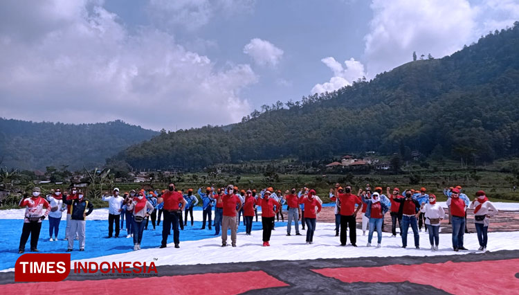 Aksi 75 atlet Paralayang yang terbang membawa Bendera Merah Putih saat mendarat di Lapangan Songgo Maruto, Kelurahan Songgokerto. (Foto: Dian for TIMES Indonesia) 