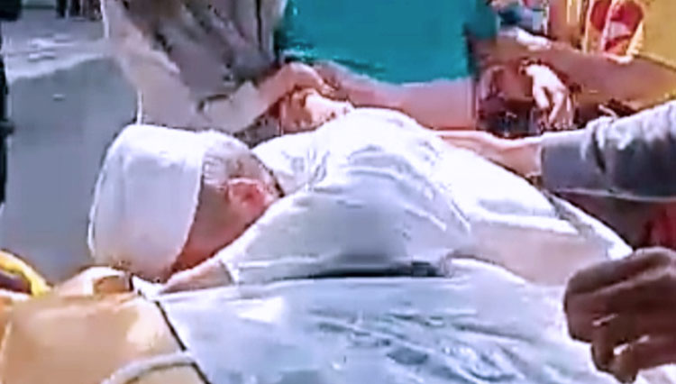 Seseorang berkopiah putih saat merebut paksa dan membuka kantor jenazah pasien Covid-19 yang terekam video. (Foto: Tangkapan layar)