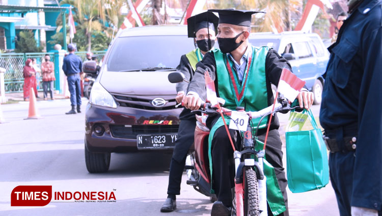 Salah seorang wisudawan di IAIN Jember saat mengikuti proses wisuda secara drive thru. Ada yang menggunakan mobil, sepeda dan motor (FOTO: Moh Bahri/TIMES Indonesia).