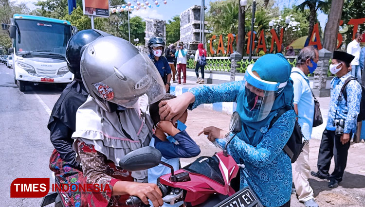 Ketua TP PKK Penta Lianawati Ahmad Dawami bersama anggota TNI/Polri dan petugas BPBD bagi masker kepada warga. (Foto: Aditya Candra/TIMESIndonesia)