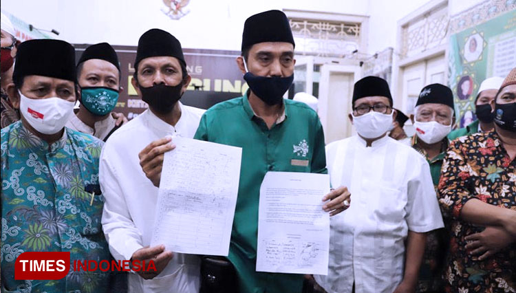 Ketua MWCNU Wonokromo H Unsi Fauzi (kemeja hijau) menunjukkan surat pernyataan sikap Forum MWCNU se-Surabaya Bersatu di Kantor PCNU Surabaya, Selasa (8/9/2020) malam. (Foto: Lely Yuana/TIMES Indonesia) 