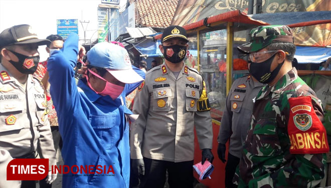 Kapolres Cirebon Kota Samsul Huda saat memakaikan masker kepada tukang becak. (Foto: dokumentasi Polres Cirebon Kota) 
