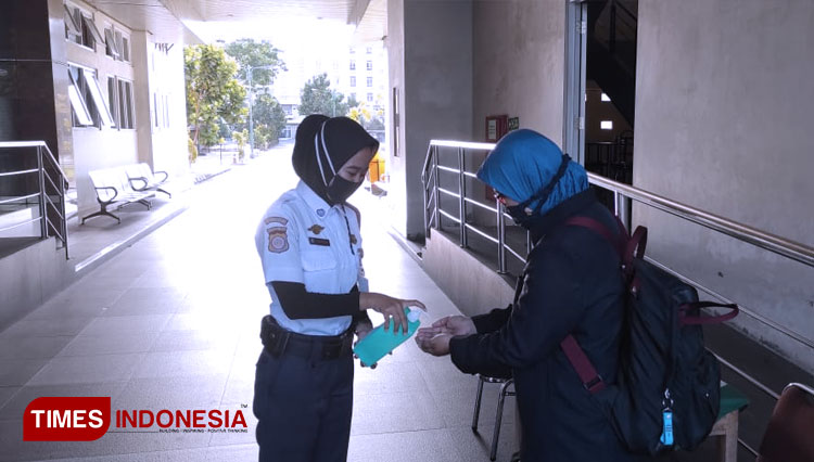 Petugas memberikan hand sanitizer kepada mahasiswi sebelum memasuki area kampus Unisa.(FOTO: Hendro S.B/TIMES Indonesia)