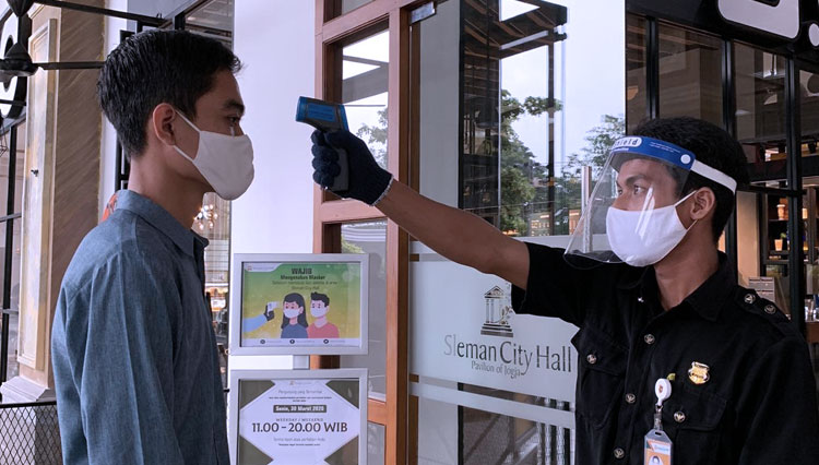 Petugas melakukan pengecekan suhu kepada pengunjung saat memasuki area mall. (FOTO: SCH for TIMES Indonesia)