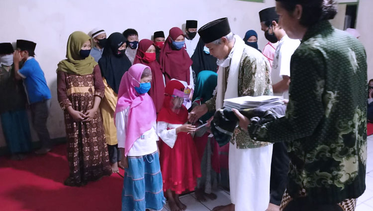 Pengasuh Majelis Ta'lim Nurul Ulum, Kiai Muhammad Mujamil menyerahkan santunan anak yatim dan Syamsul Bahri Al Tugio anggota F-PKB DPRD Banjarnegara sebagai motivator. (FOTO: Ahmad Mukodas for TIMES Indonesia)