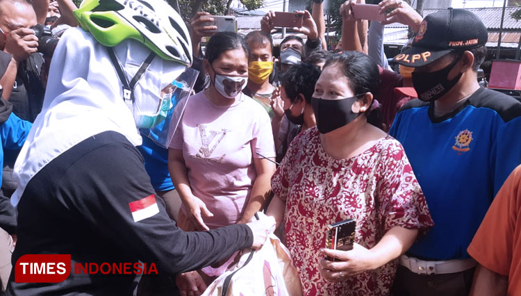 Gubernur Jawa Timur, Dra.Khofifah Indar Pawaransa saat memberikan bantuan masker dan sembako kepada warga dan pedagang di Pasar Ngemplak Tulungagung. (Foto: Zaenal Arifin/TIMES Indonesia)