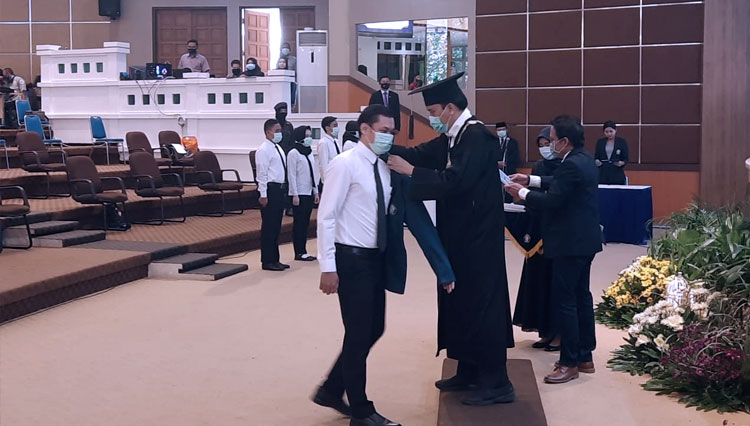 Rekotor undip memakaikan jas almamater kepada mahasiswa barunya. (FOTO: Humas)