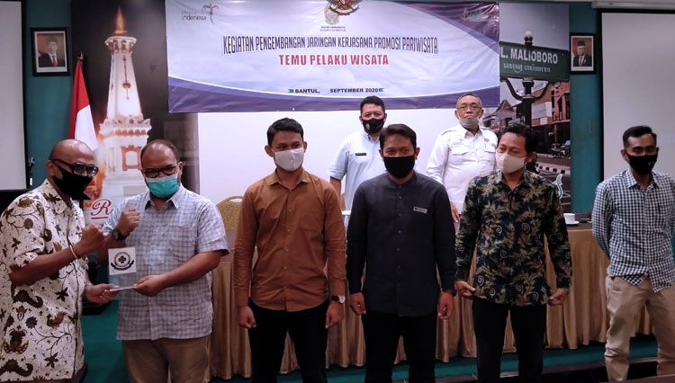 Ketua BPD PHRI DIY, Deddy Pranowo Eryono dan Kepala Dinas Pariwisata Bantul, Kwintarto ketika menyerahkan stiker kepada hotel dan restoran sebagai tanda telah menerapkan standar Protokol Kesehatan. (FOTO: PHRI Bantul for TIMES Indonesia)