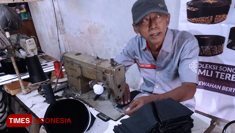 Perajin kopiah Gresik saat menjahit produknya (Foto: Akmal/TIMES Indonesia)
