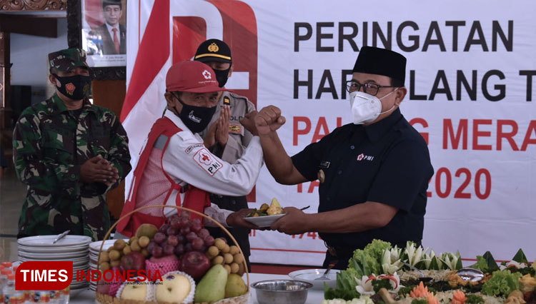 Ketua PMI Kabupaten Blitar memberikan potongan tumpeng kepada Relawan PMI di Upacara Peringatan HUT Ke 75 di Pendopo Ronggo Hadinegoro Pemkab Blitar, Kamis (17/9/2020). (Foto: Sholeh/ TIMES Indonesia)