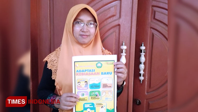 Defi Widiyasari melakukan sosialisasi pencegahan Covid-19 dengan media poster secara door to door. (FOTO: AJP TIMES Indonesia)