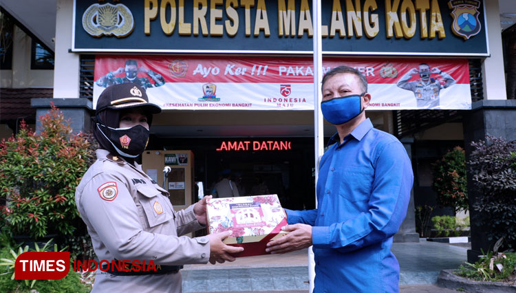 Andreas Suprayitno menyerahkan bantuan alat penyanggah masker bernama GRG kepada Anggota Polresta Malang Kota. (Foto: Naufal Ardiansyah/TIMES Indonesia)
