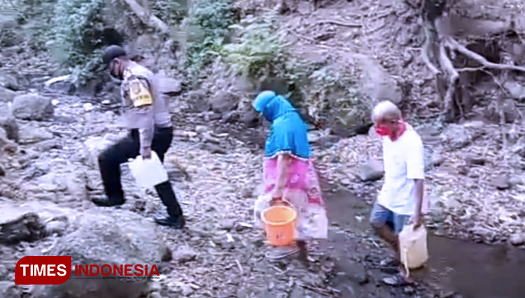 Anggota Bhabinkamtibmas Polsek Majalengka Kota, Bripka Roy Ronal membantu warga yang tengah kekeringan untuk mencari air bersih. (Foto: Jaja Sumarja/TIMES Indonesia)
