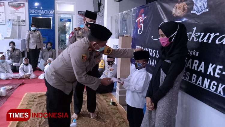 Wakapolres Bangkalan Kompol Deky Hermansyah memberikan santunan kepada anak yatim dalam rangka HUT Ke-65 Lantas Bhayangkara. (FOTO: Doni Heriyanto/TIMES Indonesia)