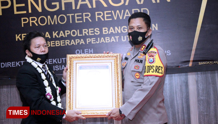 Kapolres Bangkalan AKBP Rama Samtama Putra menerima piagam penghargaan Promotor Reward dari Direktur Eksekutif LEMKAPI Edi Saputra Hasibuan. (FOTO: Doni Heriyanto/TIMES Indonesia)