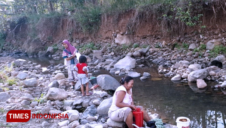 Kesulitan air di tengah musim kemarau, warga memanfaatkan air sungai untuk keperluan mandi dan mencuci. (Foto: Warga Jabungan for Times Indonesia)