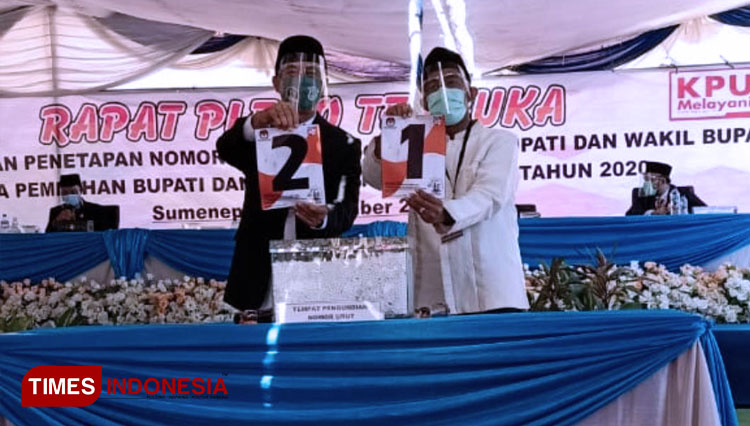 Achmad Fauzi Nomor 1 dan Fattah Jasin Nomor 2 saling menunjukkan nomor urut masing-masing di KPU Sumenep. (FOTO: Ansori/TIMES Indonesia). 