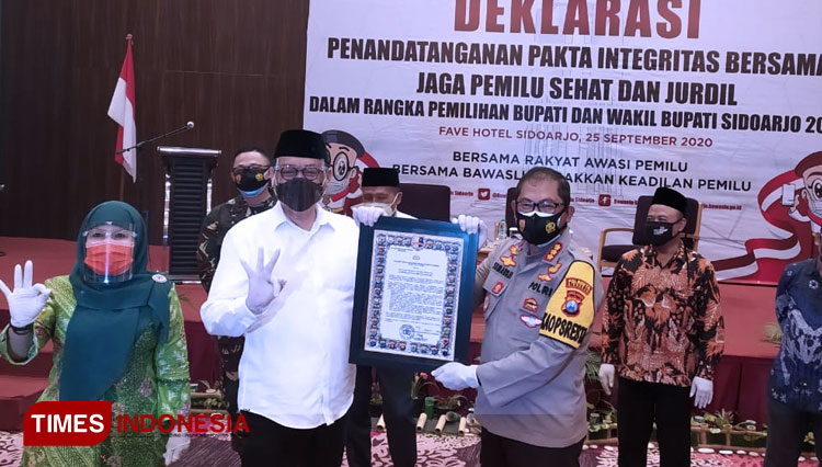 Kelana Aprilianto dan  Dwi Astutik saat menandatangani Pakta Integritas,  Pemilu Sehat dan Jurdil yang digelar KPU Sidoarjo (foto: rudi mulya/TIMES Indonesia)