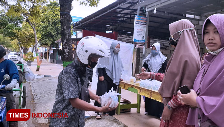 Suasana saat masyarakat mengambil nasi bungkus kepada Tim Berbagi PPMI Pacitan (FOTO: Rojihan/TIMES Indonesia)
