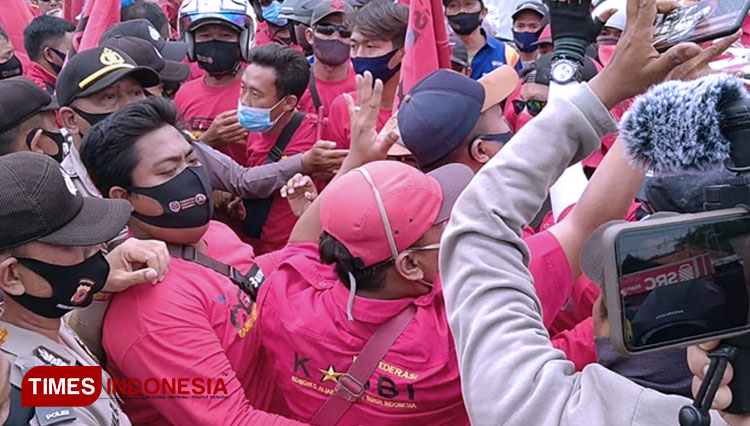 Aksi saling dorong dan adu mulut antara para buruh Pertamina dan aparat polisi saat aksi demo di Gerbang Utama PT Pertamina (Persero) RU-VI Balongan Indramayu. (Foto: Nurhidayat/TIMES Indonesia)