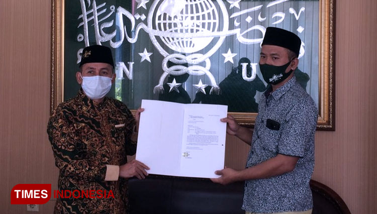 dr Taufiq Hidayat, saat menyerahkan surat Non Aktif dari kepengurusan kepada Gus Qosim, Wakil Ketua PCNU Banyuwangi. (FOTO: Syamsul Arifin/TIMES Indonesia)