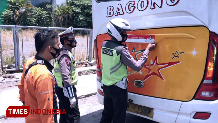 Petugas polisi lalu lintas Polresta Kediri saat menempel stiker Ayo Pakai Masker di angkutan umum. (FOTO: Canda Adisurya/TIMES Indonesia)