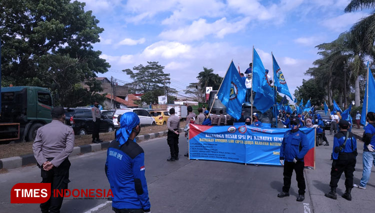 Ribuan buruh di Kabupaten Sumedang melakukan long march di Jalan Raya Bandung-Garut KM 23. (FOTO: Iwa/TIMES Indonesia)