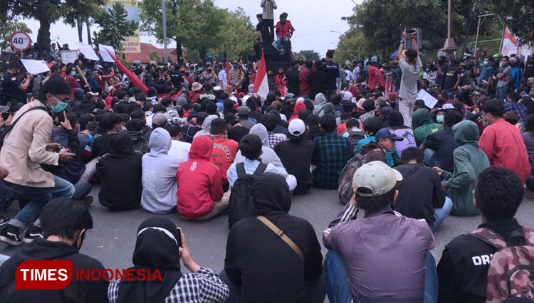 Ketua DPRD Tuban, Miyadi berdiri di atas sound system di mobil pendemo untuk menyampaikan tanggapan kaitan Aksi Penolakan Omnibus Law, Kamis, (08/10/2020). (Foto: Achmad Choirudin/TIMES Indonesia)