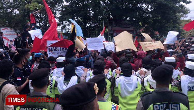 Ketua DPRD Tuban, Miyadi berdiri di atas sound system di mobil pendemo untuk menyampaikan tanggapan kaitan Aksi Penolakan Omnibus Law, Kamis, (08/10/2020). (FOTO: Achmad Choirudin/TIMES Indonesia)