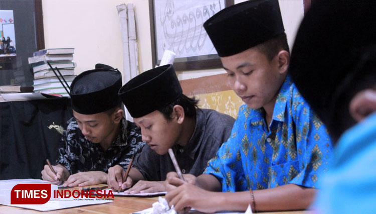 The students of MAN 4 Jombang draw the calligraphy on the paper.  (PHOTO: Rohmadi/TIMES Indonesia)