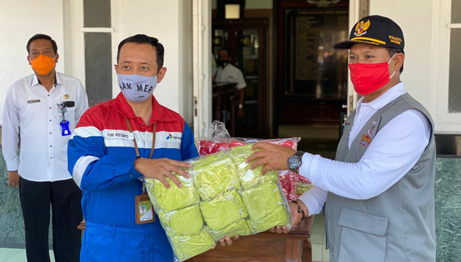 Fuel Terminal Manager Madiun, Yuri Ristanto (kiri) bersama dengan Walikota Madiun, Maidi (kanan) saat program masker gratis kepada masyarakat, Jumat (9/10/2020).(Dok.Pertamina) 