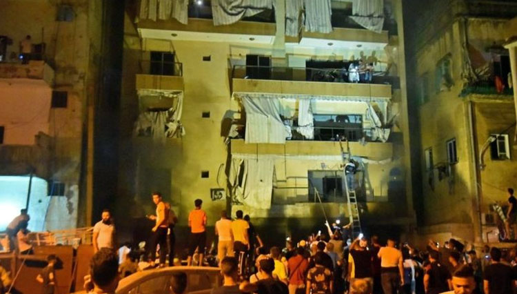 Upaya pertolongan dengan mengevakuasi penghuni gedung bertingkat di selat tempat ledakan sebuah tangki bahan bakar di Beirut, Lebanon. (FOTO: BBC/Getty Images)