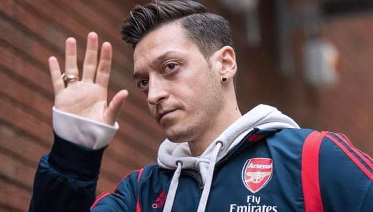 Mesut Ozil dan Gunnersaurus yang kini harus diberhentikan oleh Arsenal karena Covid-19. (FOTO: Arsenal Indonesia)
